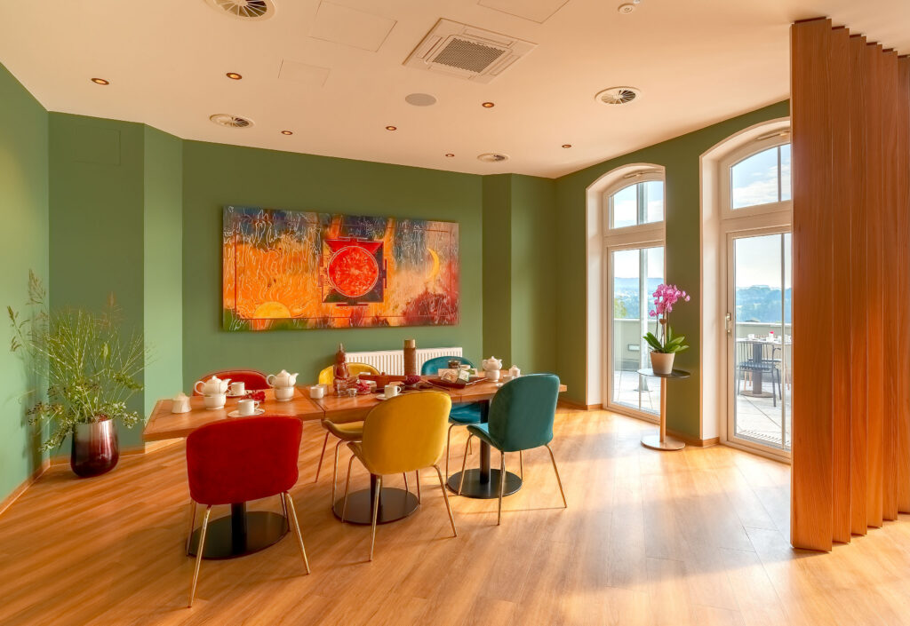 Restaurant mit farbigen Stühlen und großen Fenstern