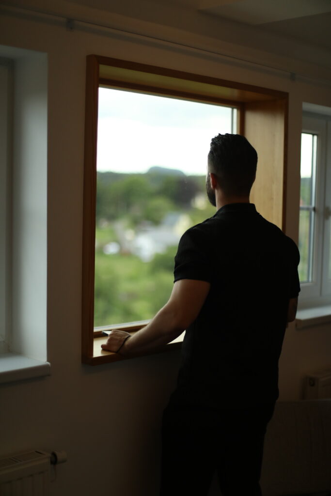 Gast am Fenster mit Blick ins Tal